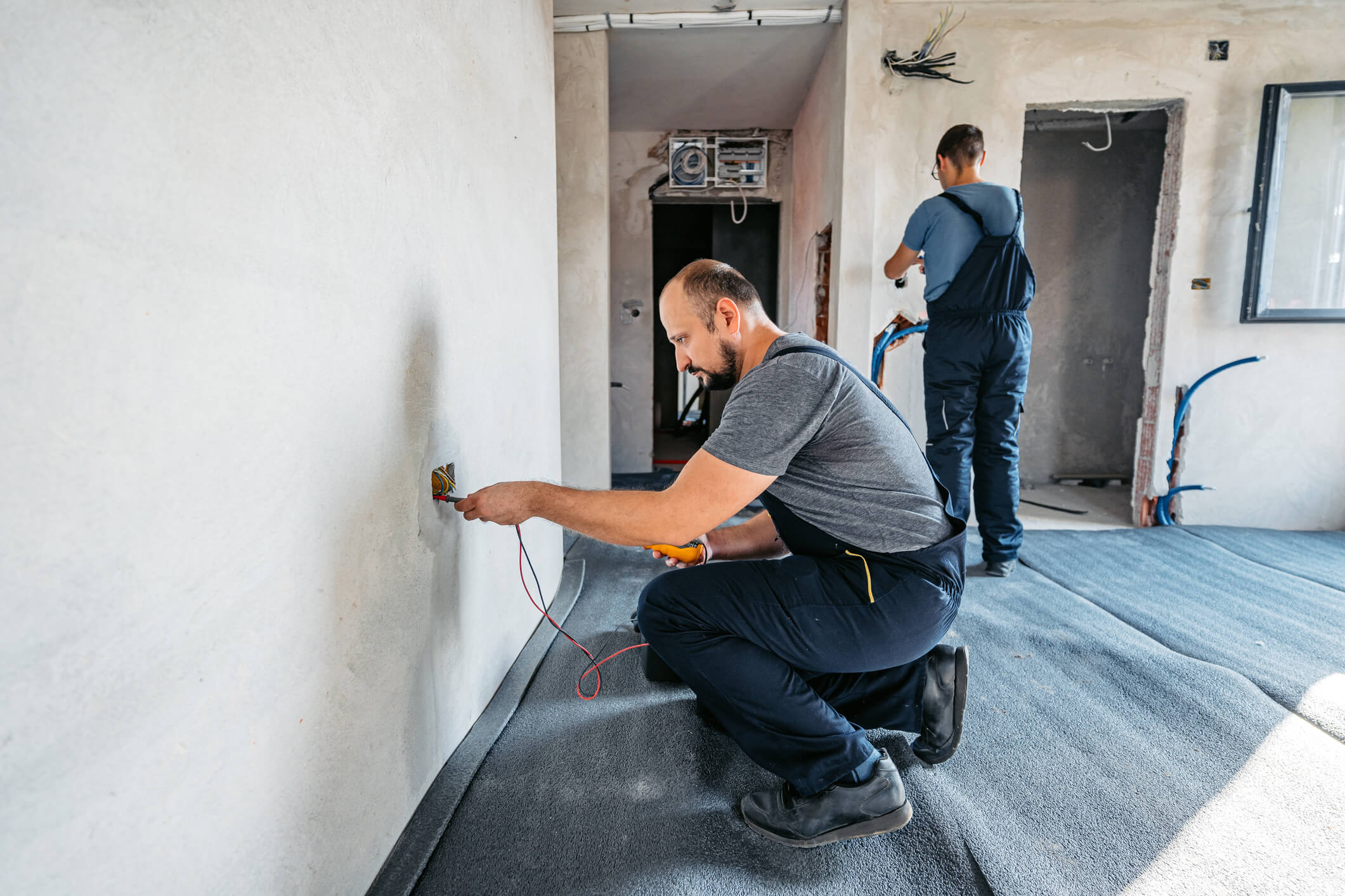 Electricians working on house wiring installation.