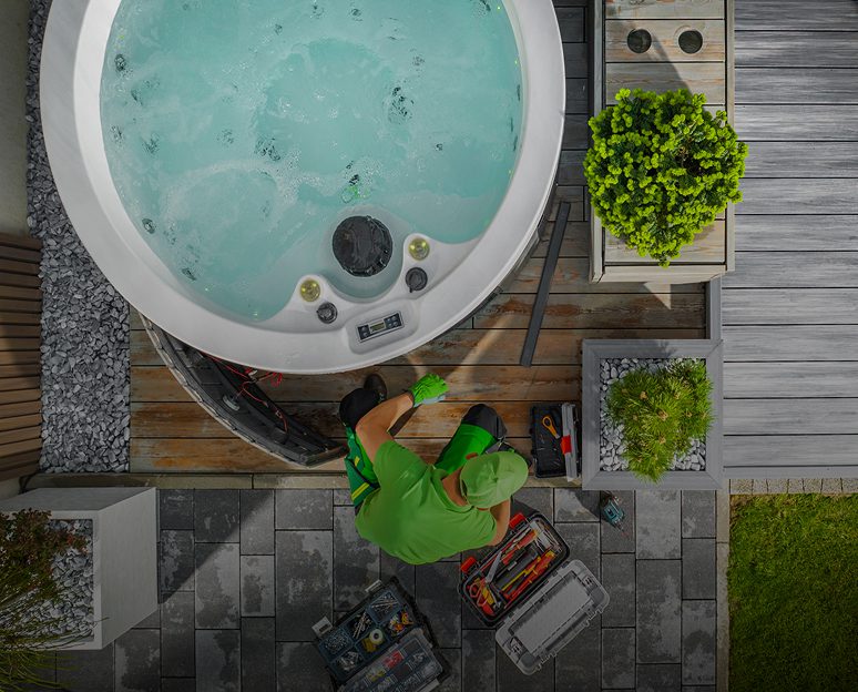 Technician repairing outdoor hot tub equipment.